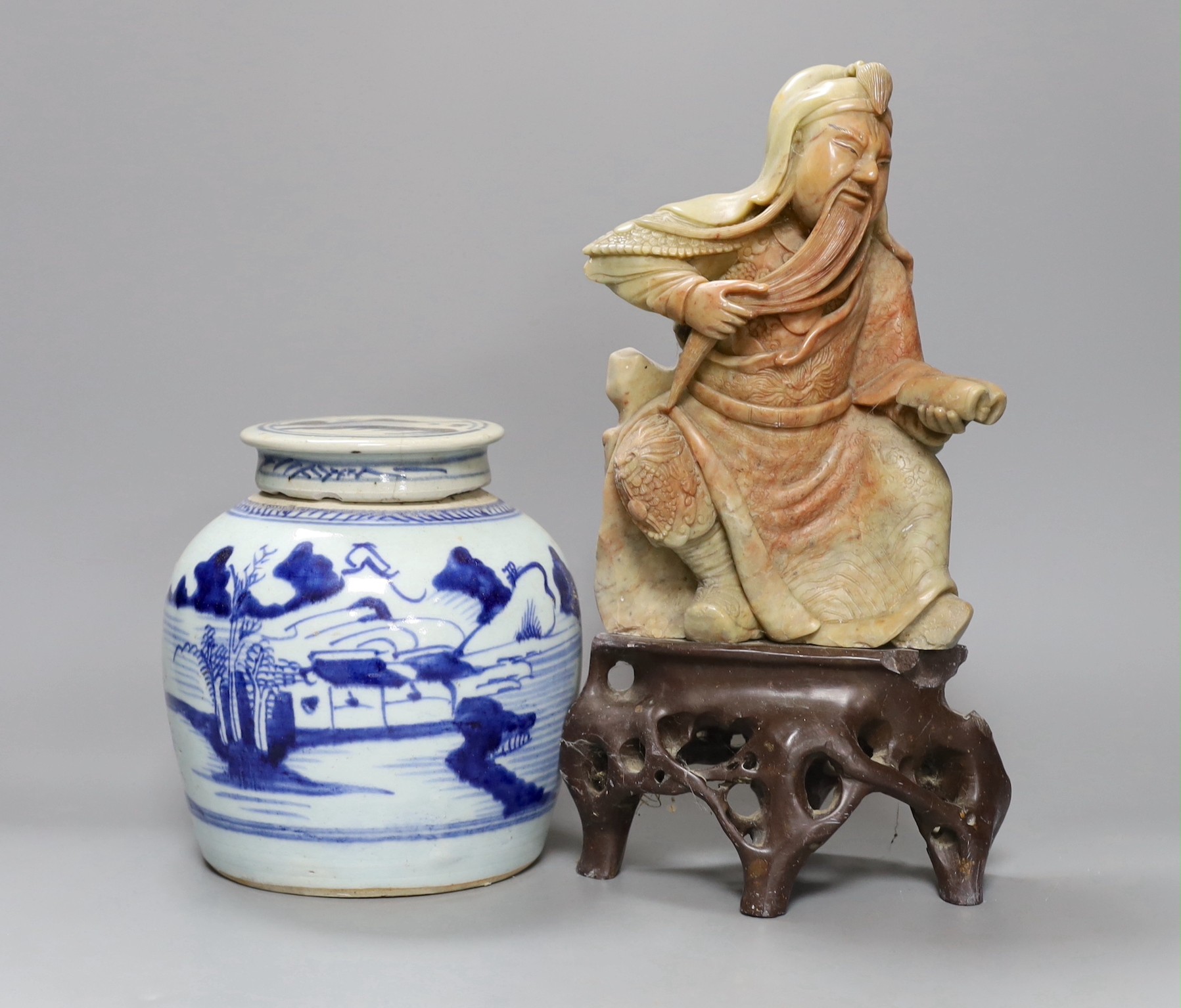 A Chinese soapstone carving of a deity and a similar early 19th century blue and white jar, tallest 30cm